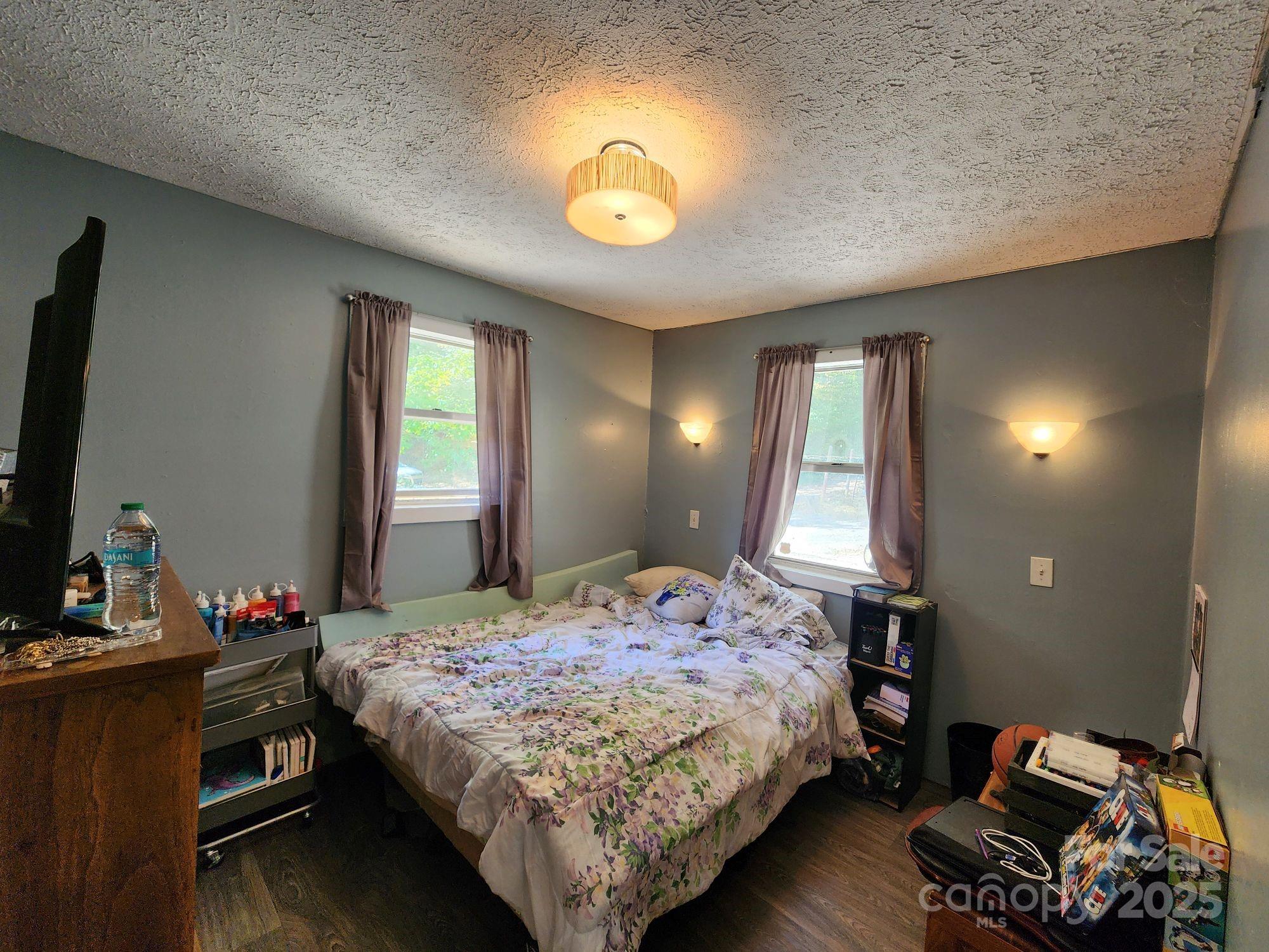 41 Gunches Dirt Road Candler, NC 28715 - Photo 20 of 33 a bedroom with a bed and a chandelier