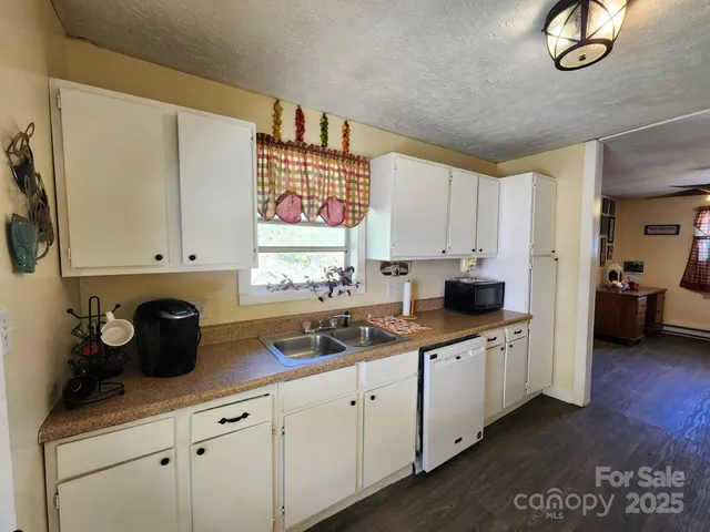 a kitchen with white cabinets and sink
