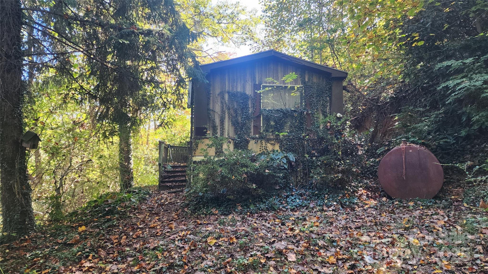41 Gunches Dirt Road Candler, NC 28715 - Photo 33 of 33 a view of a wooden house with a yard and large trees