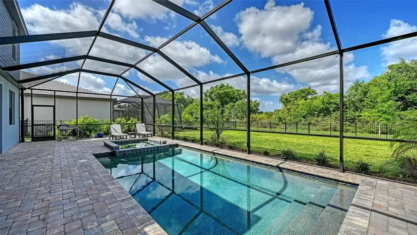 an aerial view of a swimming pool with outdoor seating
