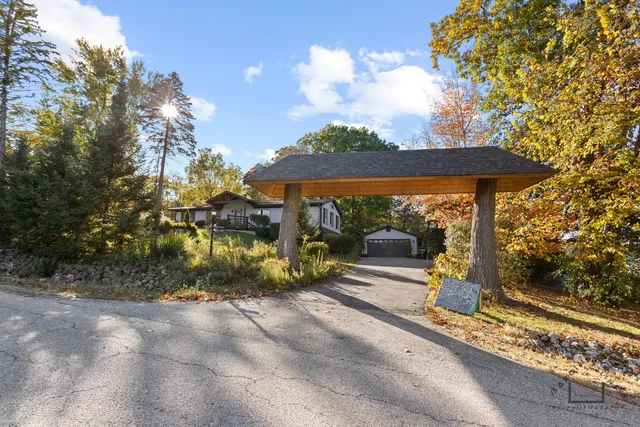 a backyard of a house with table and chairs under an umbrella