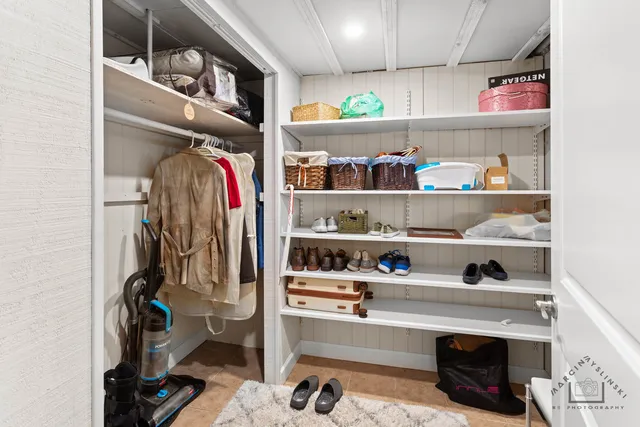 a view of walk in closet with clothes and shoes