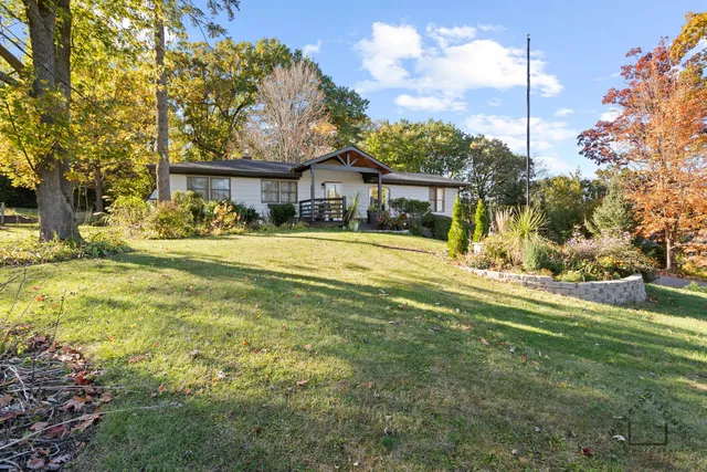 a view of a house with a big yard and palm trees