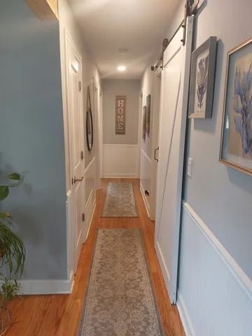 a view of a hallway with wooden floor and staircase