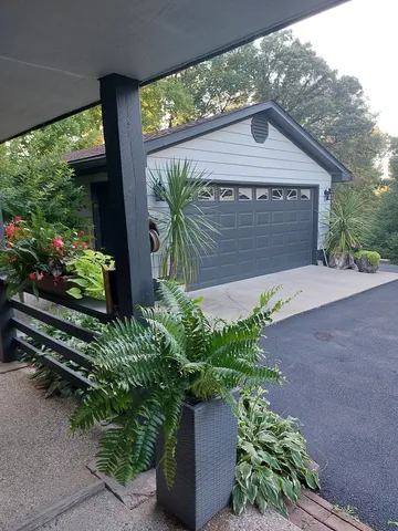 a front view of a house with a yard and potted plants