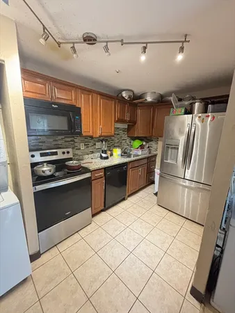 a kitchen with stainless steel appliances granite countertop a stove a refrigerator and a sink