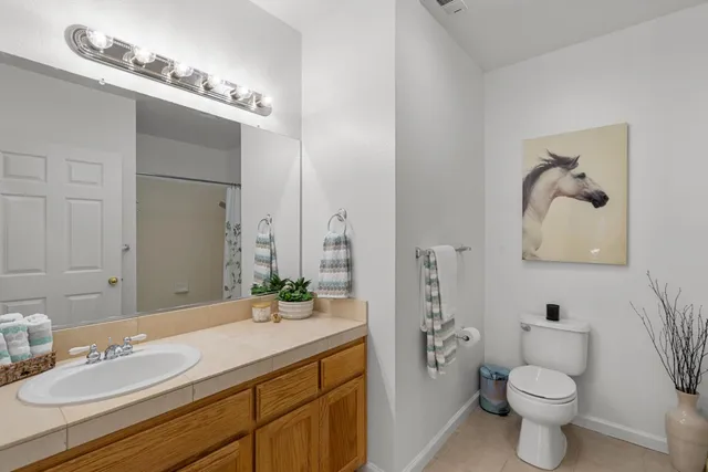 a bathroom with a granite countertop sink a toilet and a mirror