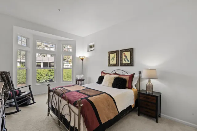 a bedroom with a bed a couch and a large window