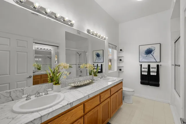 a spacious bathroom with a granite countertop double vanity and a mirror