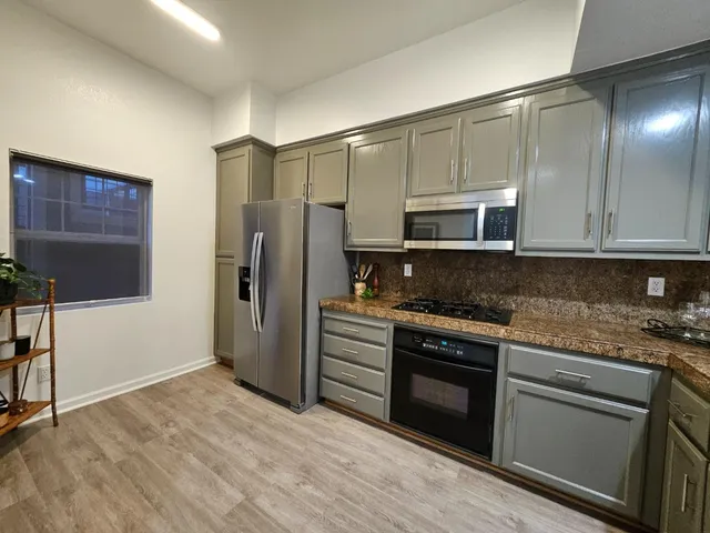 a kitchen with stainless steel appliances granite countertop a stove a refrigerator and a microwave