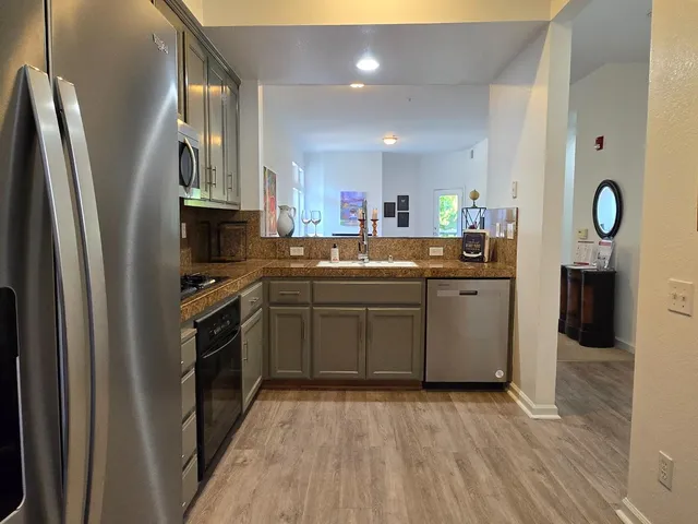 a kitchen with stainless steel appliances granite countertop a sink stove and refrigerator