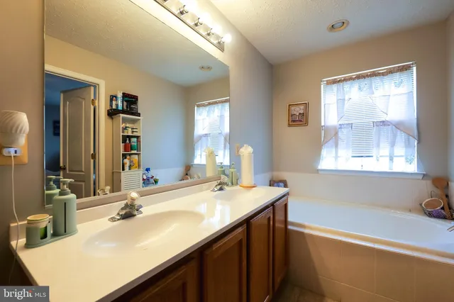 a bathroom with a tub sink and mirror