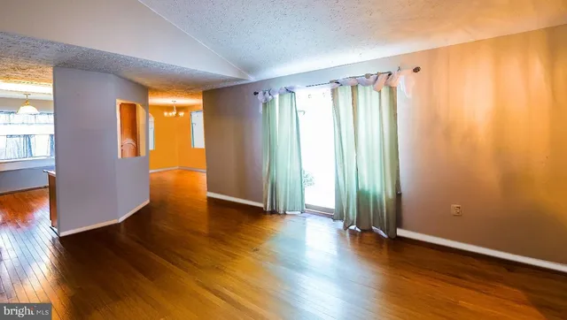 an empty room with wooden floor and a window