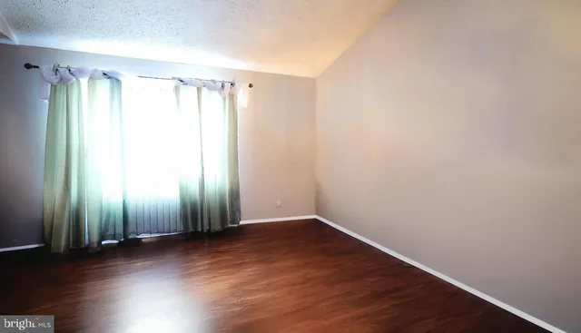 a view of a room with wooden floor and window