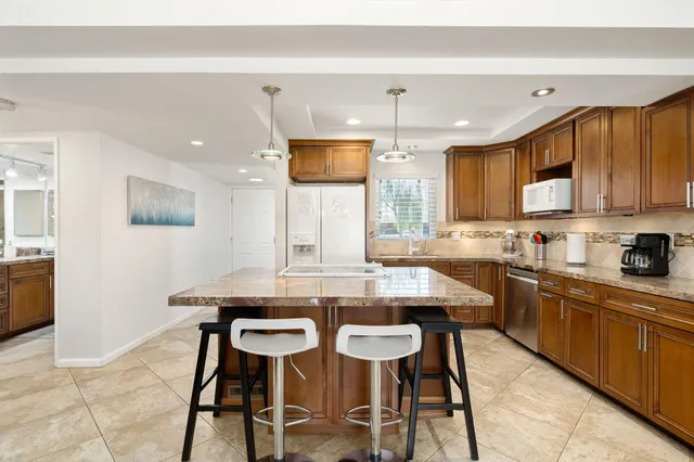 a kitchen with stainless steel appliances kitchen island granite countertop a sink and cabinets