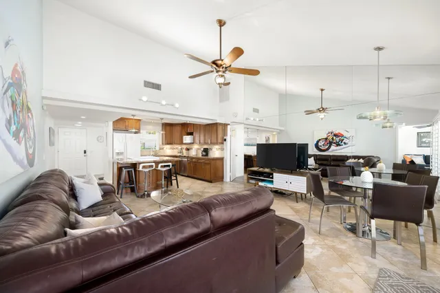 a living room with furniture kitchen view and a chandelier