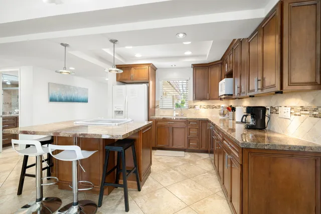 a kitchen with stainless steel appliances granite countertop table chairs sink and cabinets