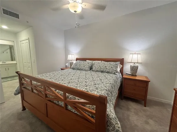 a bedroom with a bed and a mirror on dresser