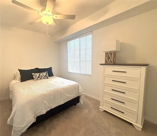 a bedroom with a bed and a ceiling fan