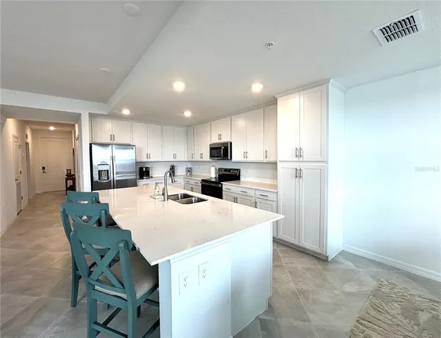 a kitchen with kitchen island wooden cabinets and refrigerator
