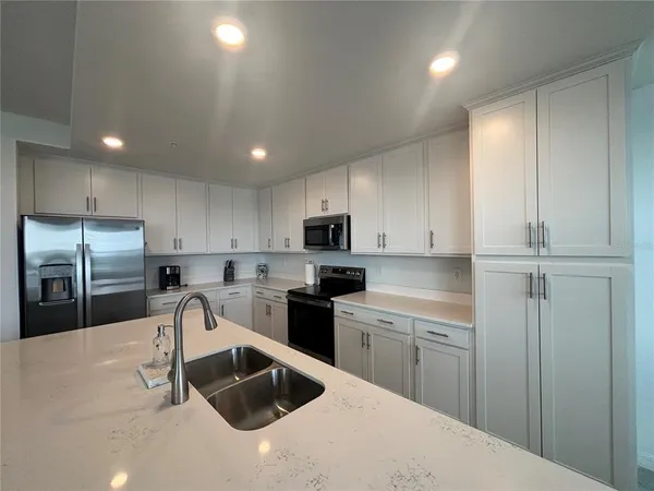 a kitchen that has a sink cabinets counter space stainless steel appliances