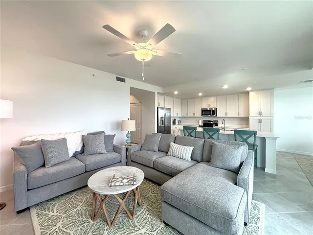 a living room with furniture and a view of kitchen