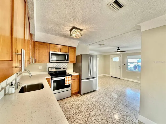 a kitchen with stainless steel appliances granite countertop a stove and a refrigerator