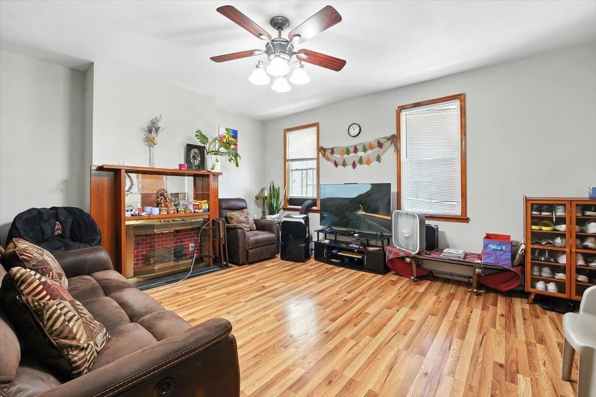 175 Van Winkle Avenue, Unit 1 Jersey City, NJ 07306 - Photo 2 of 14 a living room with furniture a fireplace and a flat screen tv
