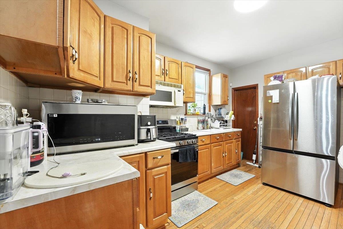 175 Van Winkle Avenue, Unit 1 Jersey City, NJ 07306 - Photo 5 of 14 a kitchen with stainless steel appliances a stove a sink and a refrigerator
