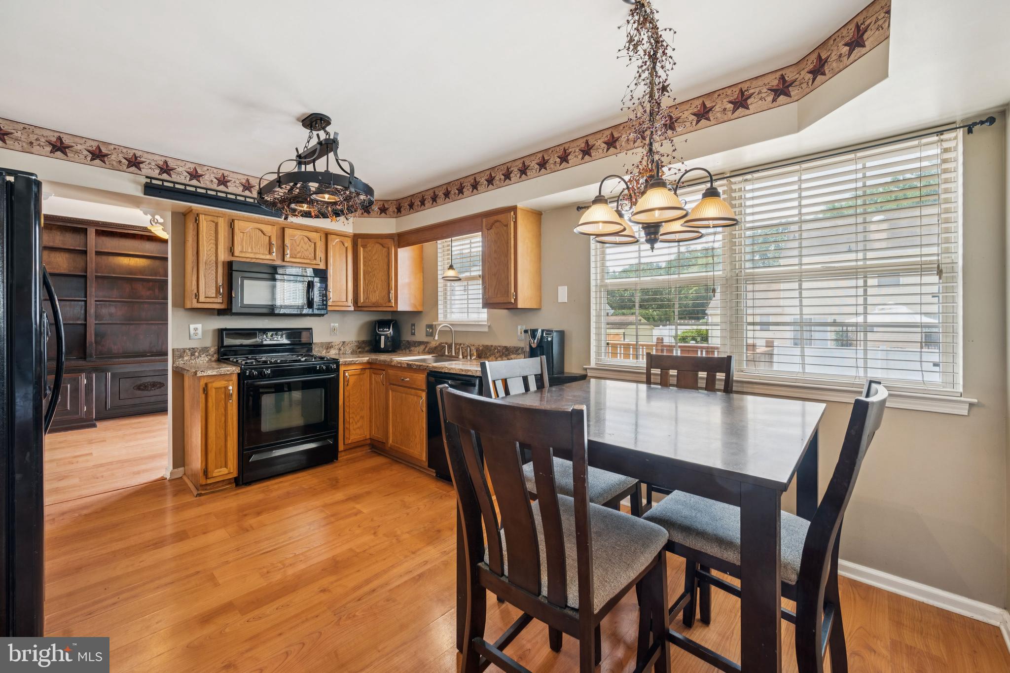 59 Country Club Road Pine Hill, NJ 08021 - Photo 8 of 25 a kitchen with stainless steel appliances granite countertop a stove top oven a sink dishwasher a dining table and chairs with wooden floor