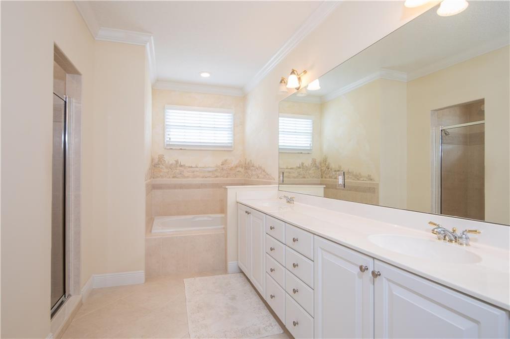 2174 Northwest Plumbago Trail Stuart, FL 34994 - Photo 14 of 26 a bathroom with a sink a mirror and a shower