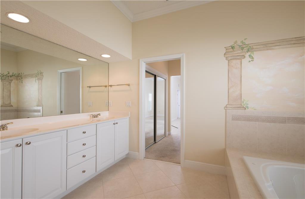 2174 Northwest Plumbago Trail Stuart, FL 34994 - Photo 16 of 26 a spacious bathroom with a double vanity sink a large mirror and a bathtub