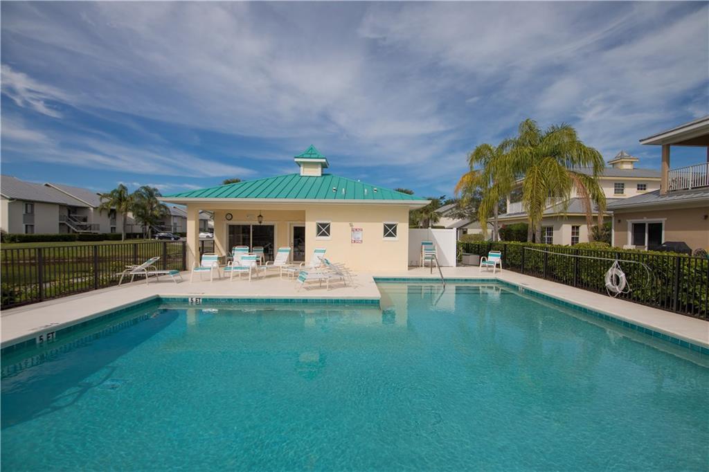 2174 Northwest Plumbago Trail Stuart, FL 34994 - Photo 22 of 26 a front view of a house with swimming pool having outdoor seating