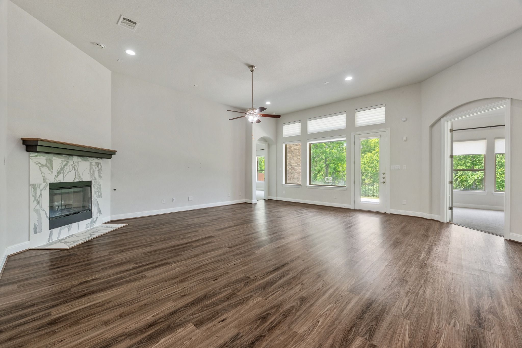 2709 Steece Way Leander, TX 78641 - Photo 10 of 39 an empty room with wooden floor fireplace and windows