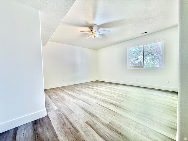 1705 80 East Tooele, UT 84074 - Photo 17 of 22 Spacious room featuring wood-finish flooring, white walls, and a ceiling fan