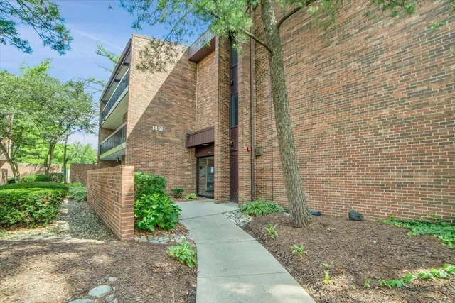 a brick building with a sink and yard next to a road