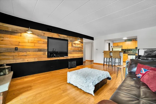 a living room with furniture floor to ceiling window and an outdoor view
