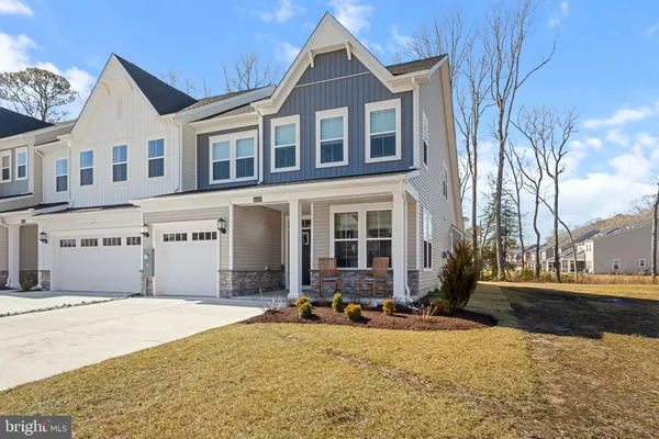 a front view of a building with cars parked on road