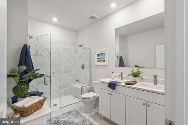 a bathroom with a double vanity sink toilet and shower