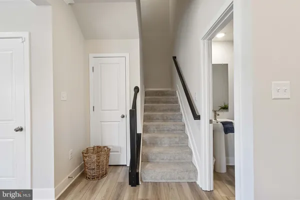 a view of front door with wooden floor and stairs