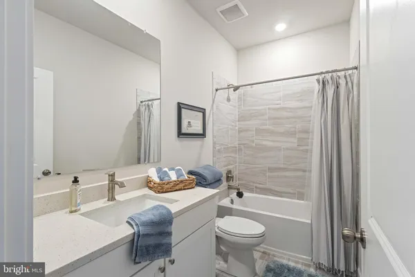a bathroom with a granite countertop sink toilet a mirror and shower