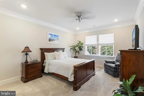 a spacious bedroom with a bed a couch and a flat tv screen