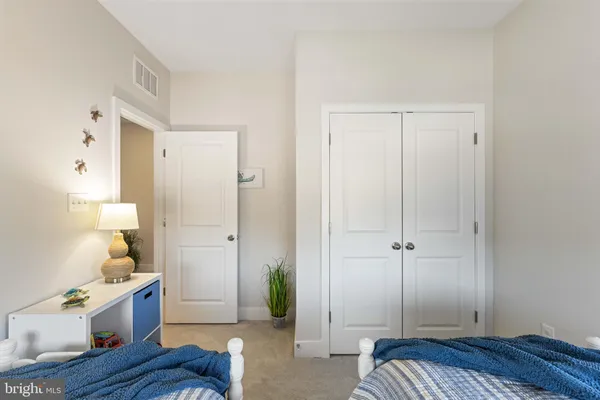 a spacious bedroom with a bed and wooden floor