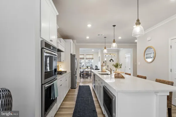 a large kitchen with kitchen island a large counter top space a sink stainless steel appliances and cabinets