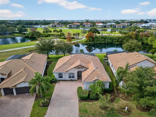 an aerial view of a house with a garden and lake view