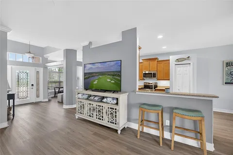 a living room with furniture a flat screen tv and a wooden floor
