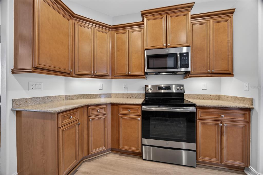 25187 Keygrass Court Punta Gorda, FL 33955 - Photo 15 of 54 a kitchen with granite countertop a stove and a microwave