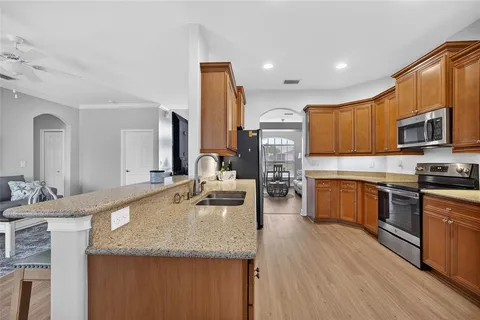 a large kitchen with granite countertop a large counter top stainless steel appliances and cabinets