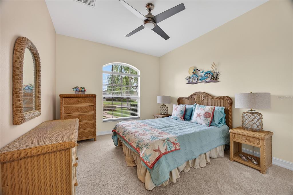 25187 Keygrass Court Punta Gorda, FL 33955 - Photo 23 of 54 a bedroom with a bed and a chandelier