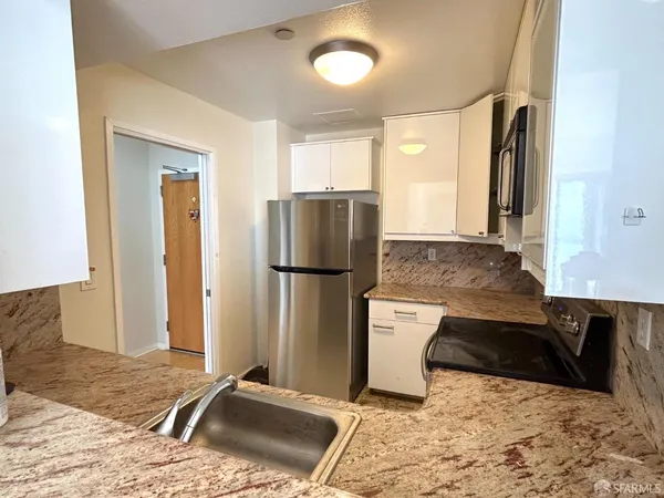 a kitchen with a refrigerator and a stove top oven